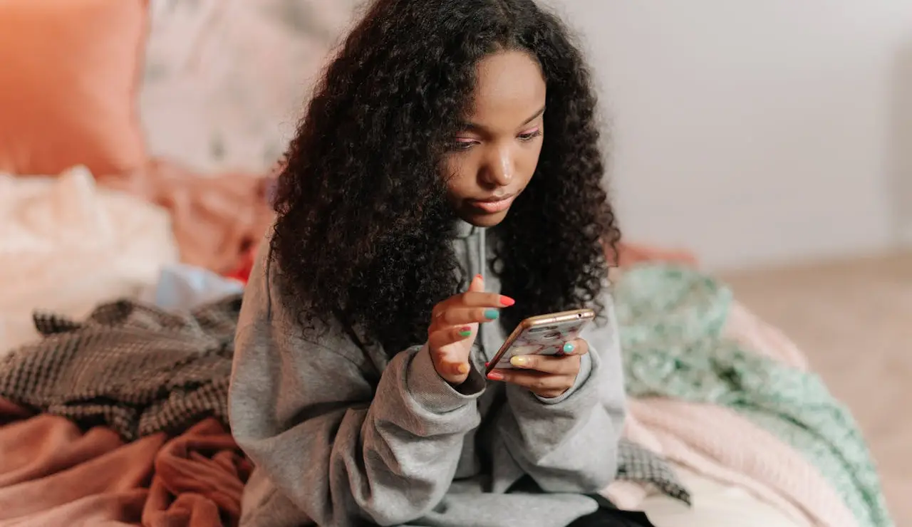 Imagen de una chica usando su teléfono móvil