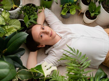 Mujer tumbada junto a unas plantas