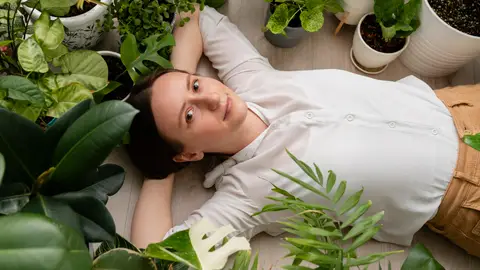 Mujer tumbada junto a unas plantas Mujer tumbada junto a unas plantas