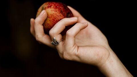 Mano sujetando una manzana
