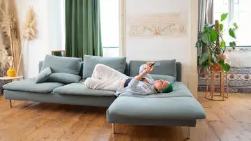 Persona tumbada en un sofá Persona tumbada en un sofá