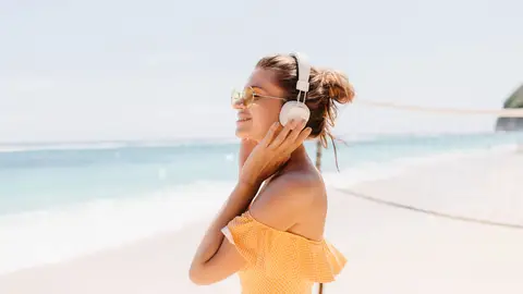Imagen de una mujer escuchando música en la playa Imagen de una mujer escuchando música en la playa