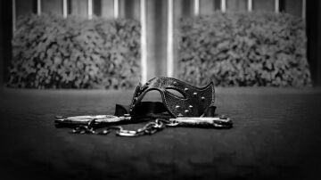 Cama con esposas y antifaz.