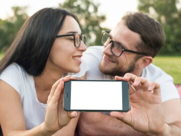 Imagen de dos personas enamoradas y un m&oacute;vil